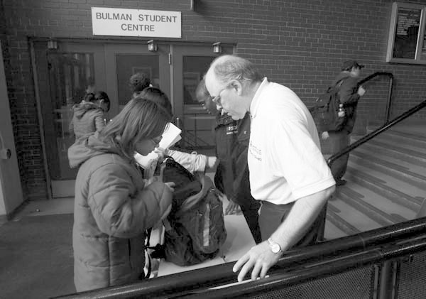 A security guard checks a student’s bag at the U of W Sept. 25. Tight security continued for days as the campus faced a shooting threat. [Photo: Mike Deal / Winnipeg Free Press, Sept. 28, 2007, reproduced with permission]