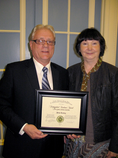 CAUT past president Loretta Czernis congratulates University of Manitoba economics professor John Loxley on winning a special academic award on May 3.